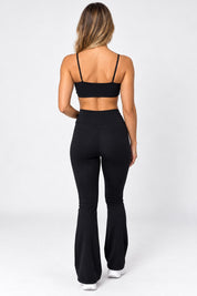 Calça flare preta cintura alta vista de costas, valorizando o bumbum com barra flare ampla